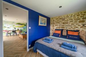 um quarto com paredes azuis e uma cama com almofadas azuis em Les gîtes d'Izel RDC em Ploemel