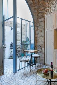a table and chairs in a room with a window at Napoleon with rooftop terrace in ‘Akko