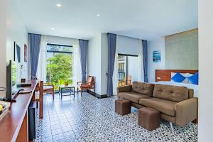 a hotel room with a couch and a bed at Kampot Sweet Boutique in Kampot
