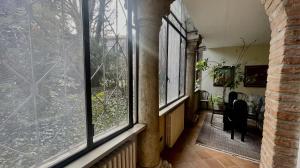 un corridoio con ampie finestre in una casa di Vizi e Virtù a Ferrara