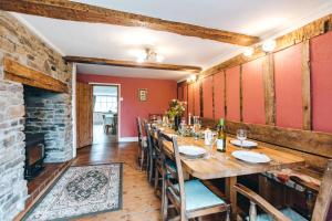 uma sala de jantar com uma mesa longa e uma lareira em Llanhedric House em Clun