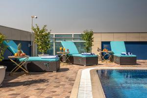 basen z krzesłami i stołem oraz basen w obiekcie Al Mansour Plaza Hotel Doha w mieście Doha