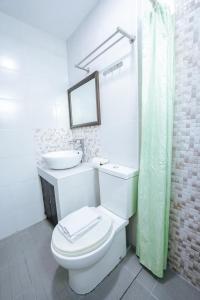 La salle de bains est pourvue de toilettes, d'un lavabo et d'un miroir. dans l'établissement Emerald Boutique Hotel, à Legazpi