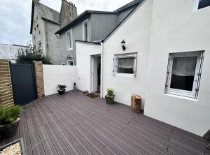 podwórko z drewnianym tarasem i doniczkowymi roślinami w obiekcie Le Wabi-Sabi - T2 duplex - terrasse privée w mieście Vannes