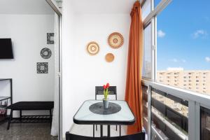 een kleine tafel op een balkon met een raam bij Home2Book Candemar Ocean View in Candelaria