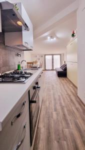 a kitchen with a stove top oven next to a living room at Guest Holiday Mandra 12 e 13 in Reggio Emilia