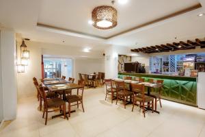 a dining room with tables and chairs and a bar at Emerald Boutique Hotel in Legazpi