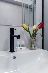 a bathroom sink with a vase of flowers and a faucet at PR 25 de Julio in Santiago de Compostela