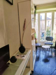 a living room with a vase on a desk at STUDIO DE L'HORLOGE in Dinan