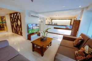 a living room with a couch and a tv at Emerald Boutique Hotel in Legazpi