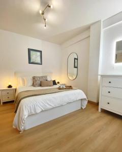 a white bedroom with a bed and a mirror at Apartamentos Oviedo centro apartastur26 in Oviedo