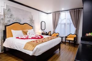 HƯỚNG DƯƠNG HOTEL THANH HOÁ في Thanh Hóa: غرفة نوم بسرير كبير عليها وردة حمراء