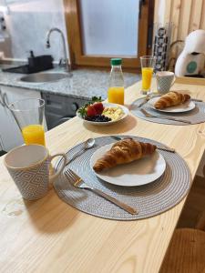 una mesa con dos platos de cruasanes y un bol de fruta en Apartamentos Oviedo centro apartastur26, en Oviedo
