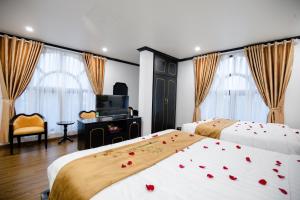 una camera d'albergo con due letti con rose sopra di HƯỚNG DƯƠNG HOTEL THANH HOÁ a Thanh Hóa