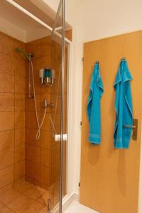 una ducha con toallas azules colgadas en la pared en Cozy basement flat, SkyShowtime, 3 minutes to center, en Praga