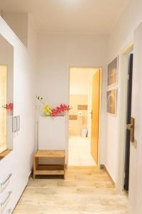 a hallway with a white room with a table with flowers on it at Cozy basement flat, SkyShowtime, 3 minutes to center in Prague