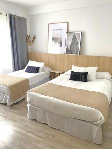 ein Hotelzimmer mit 2 Betten in einem Zimmer in der Unterkunft Pensión Residencia Fornos in Santiago de Compostela