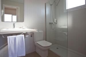 a bathroom with a toilet and a sink and a shower at Seth Playa Azul in Cala en Porter