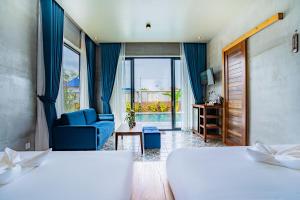 a hotel room with two beds and a blue couch at Kampot Sweet Boutique in Kampot