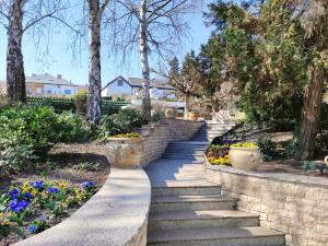 a set of stone stairs in a garden with flowers at Spa Residence Carbona Water Lily Apartment in Hévíz