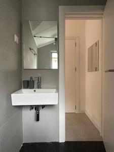 La salle de bains est pourvue d'un lavabo blanc et d'un miroir. dans l'établissement Villa Vele, à Herceg-Novi