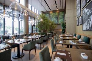 a restaurant with wooden tables and chairs and windows at LK Design Hotel Florianópolis in Florianópolis