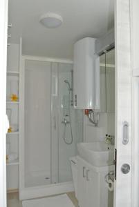 a white bathroom with a shower and a sink at Stella blue Floating House Portorož in Portorož