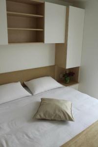 a white bed with a pillow on top of it at Stella blue Floating House Portorož in Portorož