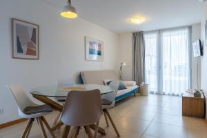 een woonkamer met een tafel en stoelen en een bank bij Atlantic Sagres in Sagres