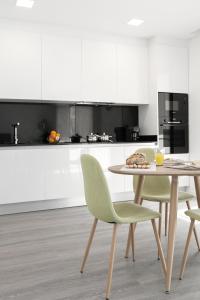 una mesa y sillas en una cocina con armarios blancos en Consolação Blue Paradise, en Consolacao