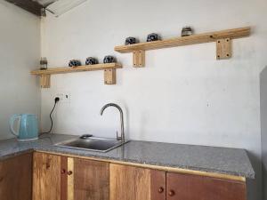 a kitchen counter with a sink and wooden cabinets at Bluesea Homestay in Phu Yen