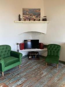 two green chairs and a television in a living room at Villa Katina in Arethousa