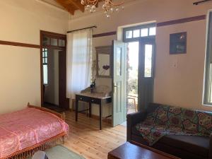 a bedroom with a bed and a desk and a couch at Villa Katina in Arethousa