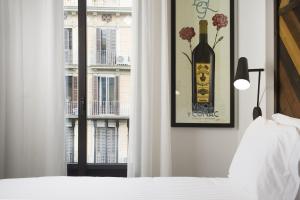 Un dormitorio con una botella de vino y una ventana en Praktik Vinoteca, en Barcelona
