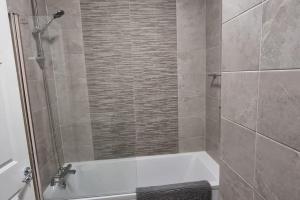 a bathroom with a shower and a bath tub at 2 Bed Gated Apartment Westport in Westport