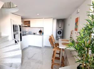 a kitchen with white cabinets and a table and chairs at New beachfront duplex - sleeps up to 4 in Gibraltar