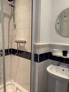 uma casa de banho com um chuveiro e um lavatório. em Montclare em Llandudno