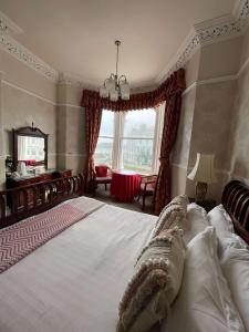 um quarto com uma cama grande e uma janela em Montclare em Llandudno