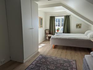 Schlafzimmer mit einem Bett und einem Fenster in der Unterkunft Magasinet in Fredrikstad