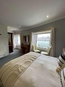 Un dormitorio con una gran cama blanca y una ventana en Montclare, en Llandudno