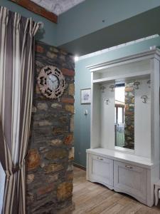 a room with a stone wall and a mirror at Green House Skiathos in Skiathos
