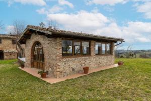 a small stone house in a grassy field at La Badia in Gambassi Terme