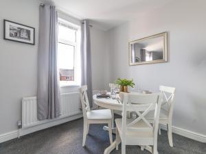 een witte eetkamer met een witte tafel en stoelen bij Lilys Apartment 2- 2bedroom, Northumberland in Bedlington