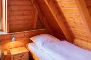 ein kleines Zimmer mit einem Bett in einer Holzhütte in der Unterkunft OH 42 - Strandvogt Komfort in Dorum Neufeld