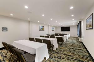 a row of tables and chairs in a room at La Quinta by Wyndham Des Moines West Clive in Clive