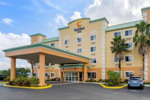 ein Hotel mit einem Auto auf einem Parkplatz in der Unterkunft Comfort Inn Kissimmee-Lake Buena Vista South in Kissimmee