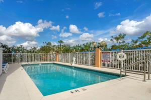 una piscina en un complejo con una valla en Comfort Inn Kissimmee-Lake Buena Vista South en Kissimmee