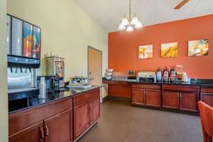 a large kitchen with orange walls and a counter at Comfort Inn Kissimmee-Lake Buena Vista South in Kissimmee