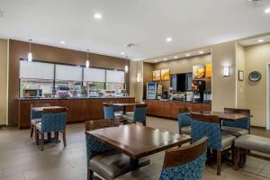 a restaurant with tables and chairs and a counter at Comfort Suites in Macon