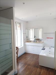 a white bathroom with a sink and a tub at Le Relais des Roses- Chambres d'hôtes in Vatan